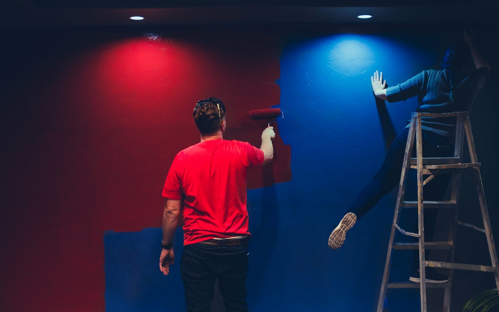 man and woman painting wall